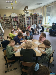 Dzieci siedzą przy stolikach Dzieci siedzą przy stolikach