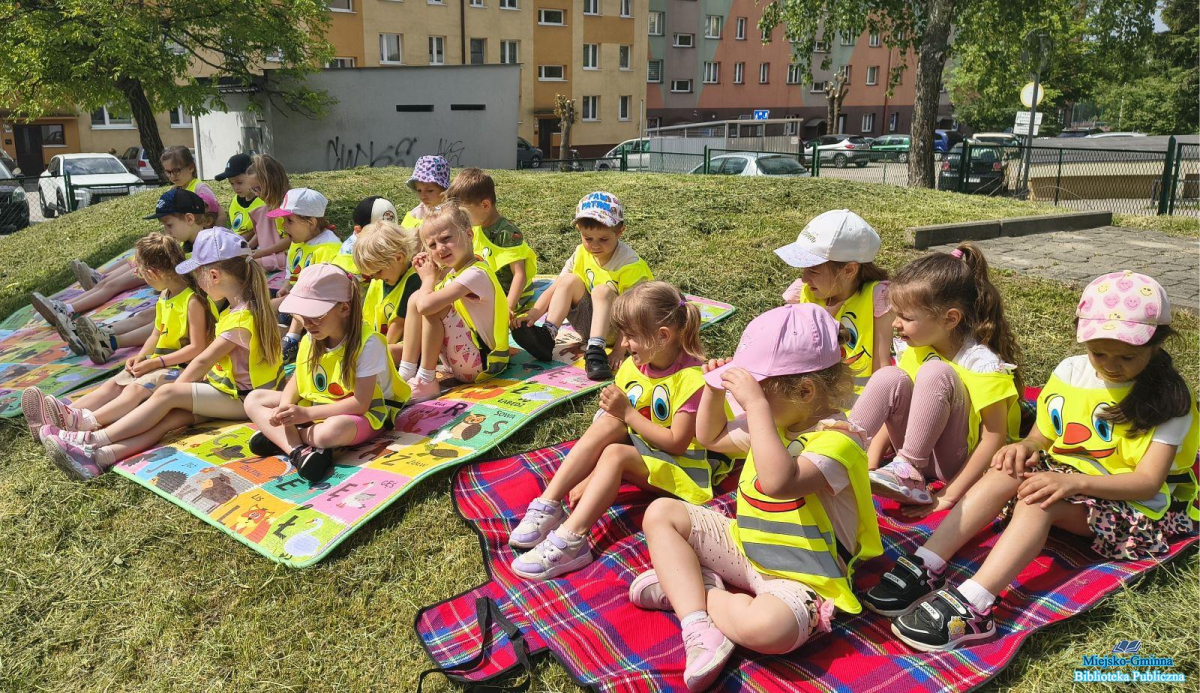 Dzieci siedzą na kocach i słuchają Dzieci siedzą na kocach i słuchają