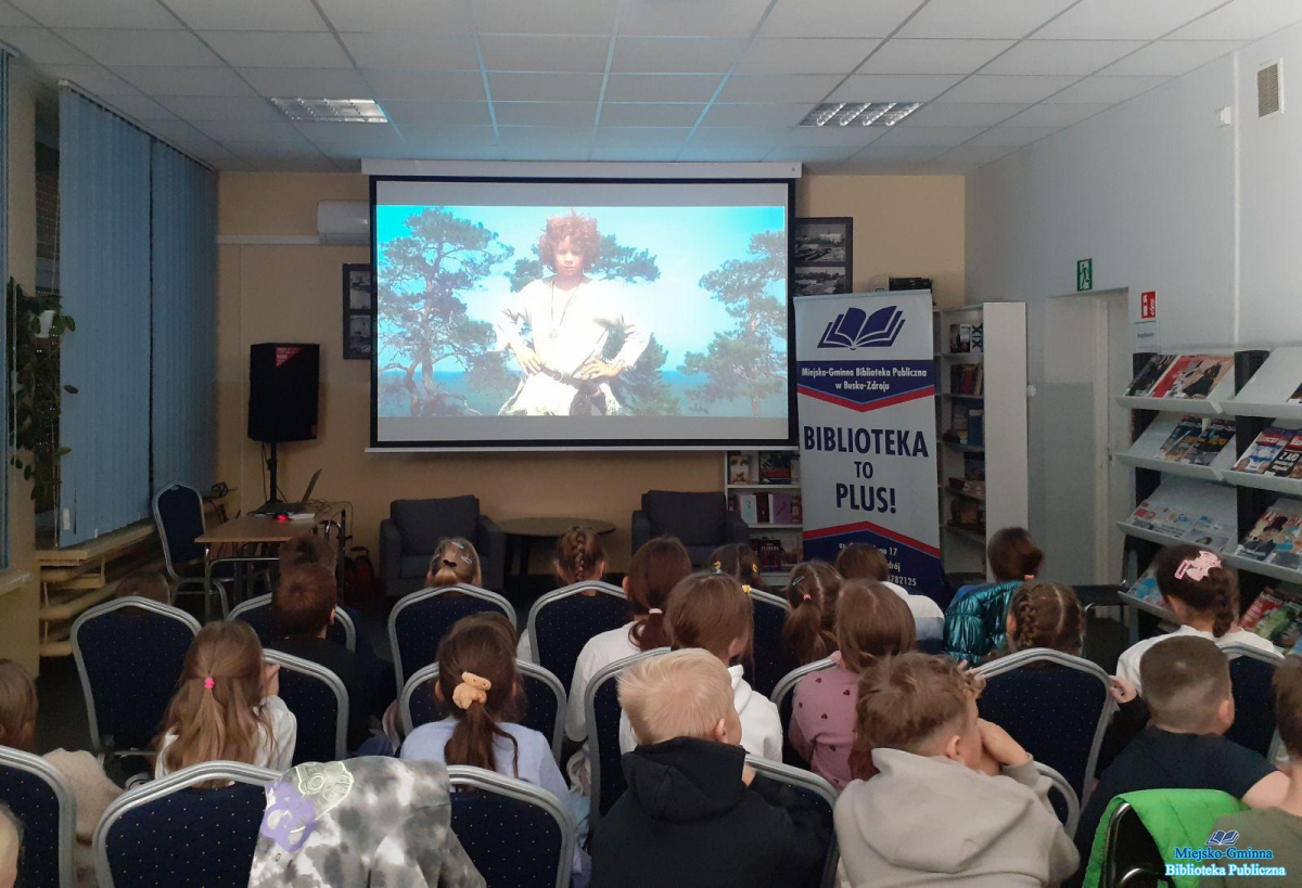 Najmłodsi siedzą i oglądają seans filmowy Najmłodsi siedzą i oglądają seans filmowy