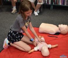 Dziewczynka uczy się pierwszej pomocy